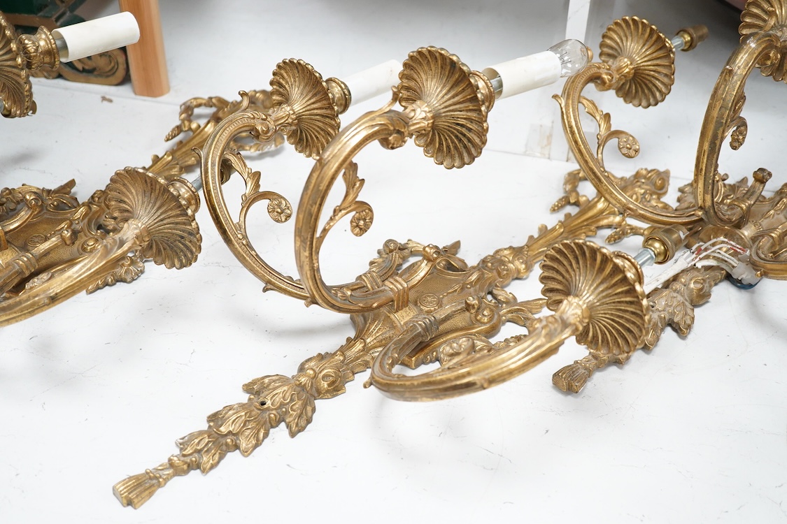 A set of four Louis XVI style three branch gilt bronze wall lights, 62.5cm high x 40cm wide